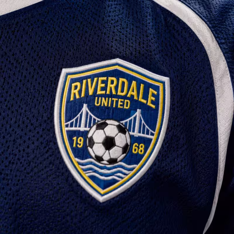 Embroidered Riverdale United soccer team patch featuring a bridge soccer ball and the year 1968 on a blue jersey