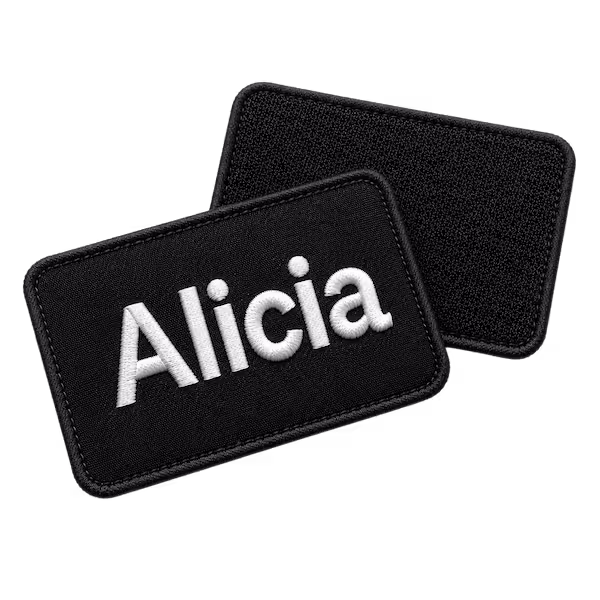 Black rectangular embroidered name patch with white text Alicia showing black hook and loop velcro backing